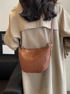 Brown vintage minimalist bucket shoulder bag with gold zipper and smooth leather texture