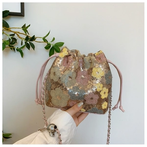 Dettaglio di una borsa a secchiello di paillettes con motivi floreali e catena