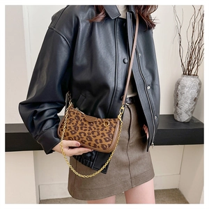 Detailed view of leopard print crossbody bag with gold chain and leather trim