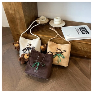 Detailed display of three bucket bags in white, brown, and khaki with cute bear pendants