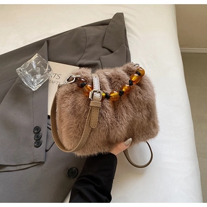 Detailed shot of faux fur bucket bag with amber bead handle and adjustable leather strap