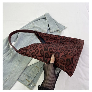 Detail of vintage leopard print tote bag in dark red and black with stylish leather straps