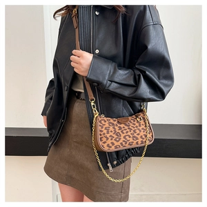 Detail of leopard print shoulder bag with brown leather trim and gold chain strap