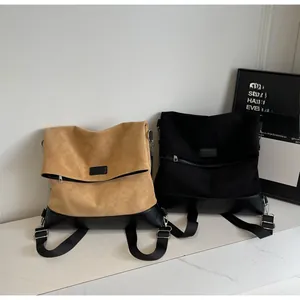 Close-up of suede and leather tote bags in khaki and black with minimalist flap design