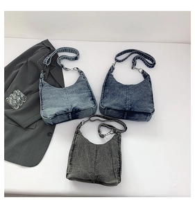 Detailed close-up showing three vintage washed denim half-moon shoulder bags in various colors