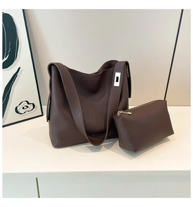 Detail of dark brown tote bag set with wide shoulder strap and silver metal buckle