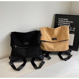 Detail of minimalist suede patchwork backpacks in black and khaki with wide straps