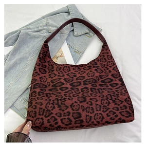 Detail of burgundy leopard print tote bag with soft suede texture and leather handle