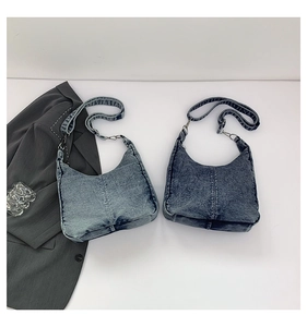 Detail view of denim hobo bags in light and dark blue with vertical stitching