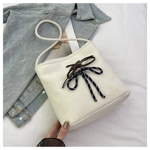 Close-up of canvas bucket bag with VILA lettering and striped decorative ribbon detail
