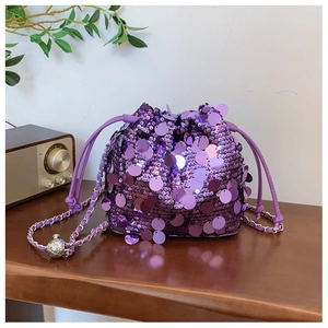 Dettaglio borsa a secchiello con paillettes viola e catena con sfera di metallo