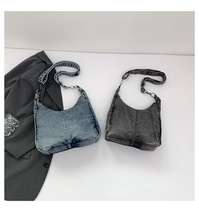 Detail view of vintage denim shoulder bags in blue and grey with silver hardware