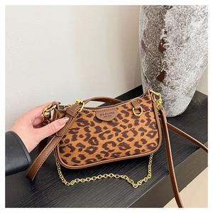 Close-up of leopard print small square bag featuring gold chain and brown leather strap