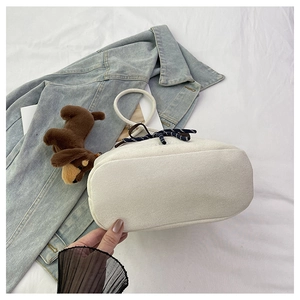 Detailed close-up of soft plush fabric texture and blue polka dot bow on white bucket bag