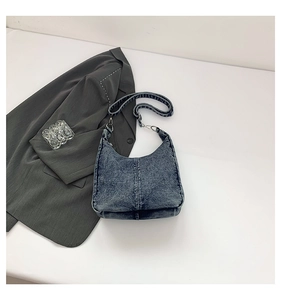 Detail view of vintage washed blue denim hobo bag with a stylish jacquard strap