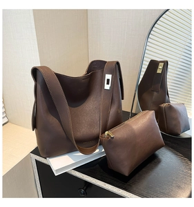 Deep brown leather bucket bag set with wide strap and matching zipper pouch details