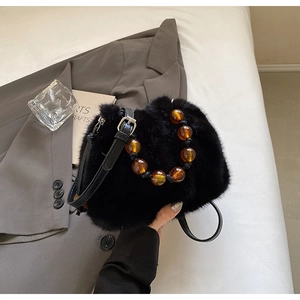 Detail of black faux fur bucket bag featuring amber acrylic beads and leather strap