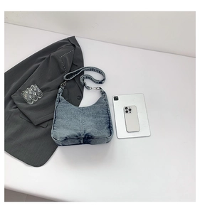 Detail showing vintage washed blue denim hobo bag with stitching and silver metal buckle