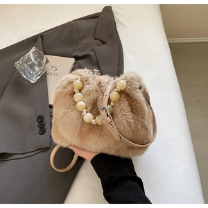 Detail of faux fur bucket bag with yellow resin beaded handle and leather strap