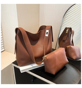 Detailed view of brown leather bucket bag with silver metal buckle and matching pouch