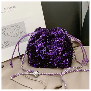 Dettaglio borsa a secchiello con paillettes viola e ciondolo a teschio in argento