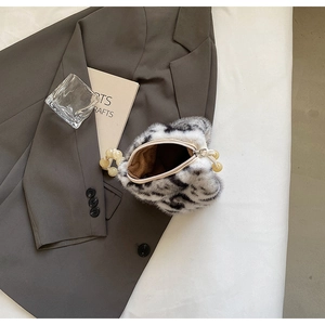 Detail shot of leopard faux fur bucket bag with white bead handle on grey blazer