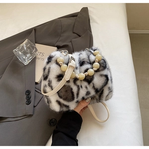 Close-up of leopard print faux fur bucket bag with beaded handle and leather strap