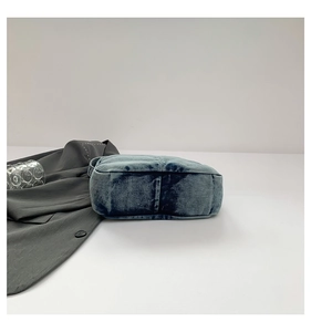Side view of washed denim tote bag showing wide base and stitching details on white