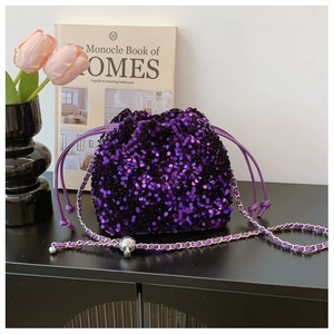 Dettaglio borsa a secchiello con paillettes viola, catena argento e coulisse