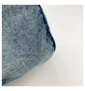 Close-up of blue denim fabric with twill texture and sturdy double-needle stitching detail