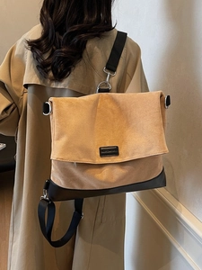 Large khaki suede backpack with black leather base and wide adjustable nylon strap