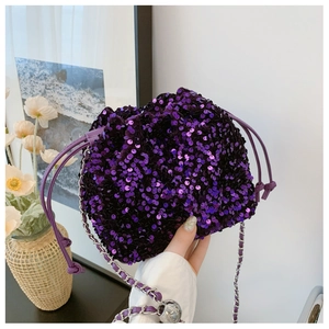Dettaglio ravvicinato di una borsa a secchiello con paillettes viola e catena d'argento