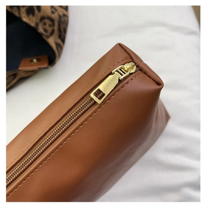 Detail of the golden zipper closure and stitching on the brown leather storage bag