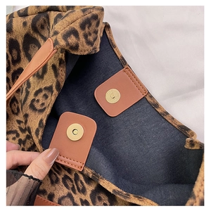 Detail view of leopard print tote bag with magnetic metal clasp and black fabric lining