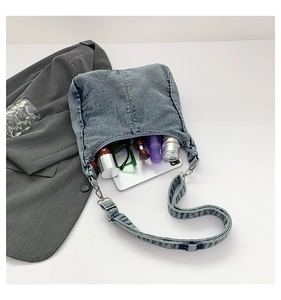 Blue denim hobo bag interior view showing large capacity for cosmetics and phone