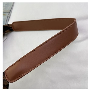 Detail shot of brown leather strap with precise stitching on a leopard print tote bag