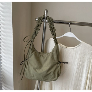 Detailopname van de olijfgroene cloud bag met trekkoord en geplooide nylon schouderband