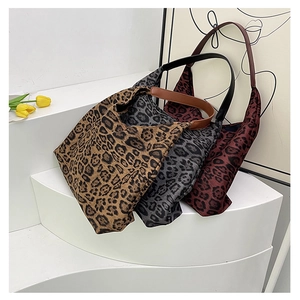 Detailed view of leopard print canvas tote bags in khaki, grey, and reddish brown colors