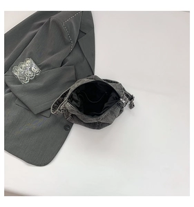 Top view of a retro grey washed denim crossbody bag with internal pocket and zipper detail