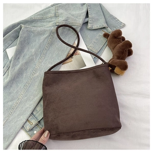 Detailed texture of the dark brown suede bucket bag featuring premium matte finish