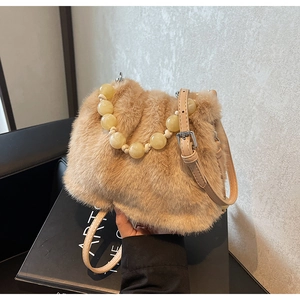 Detailed texture of fluffy faux mink fur bucket bag with pearl handle and leather strap