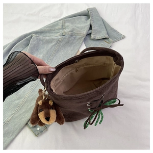 Detail view of the brown suede bucket bag with inner lining and secure zipper pocket