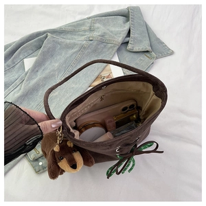 Close-up of brown suede bucket bag interior showing capacity for cosmetics and accessories