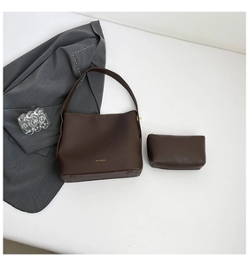 Detail view of dark brown leather tote bag set including matching small zippered pouch