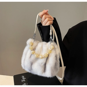 Detail of faux fur crossbody bag with luxury beaded handle and white leather shoulder strap