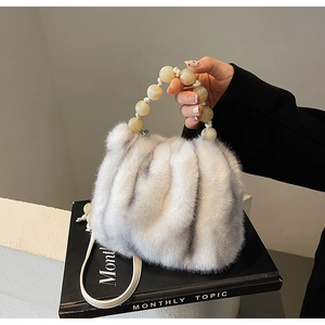 Detail showing plush faux mink fur texture and yellow resin beaded handle of bucket bag