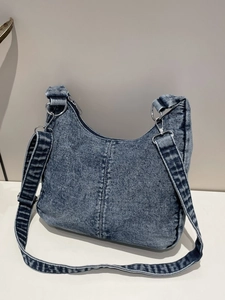 Retro washed denim blue half-moon shoulder bag with silver hardware and adjustable strap