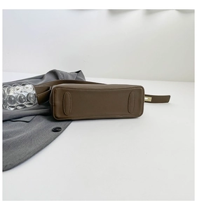 Detail view of the brown leather bucket bag bottom with reinforced wear-resistant patches