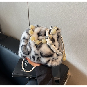 Detail of faux fur leopard bucket bag with beaded handle and leather shoulder strap