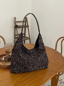 Vintage leopard print tote bag in dark grey canvas shown on a wooden cafe table